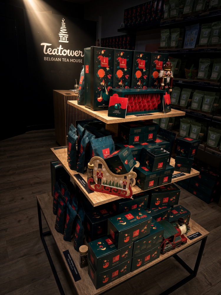 Présentoir de Noël 2026 en boutique Teatower : calendrier de l'Avent, coffrets, traîneau et train de Noël devant le logo Belgian Tea House